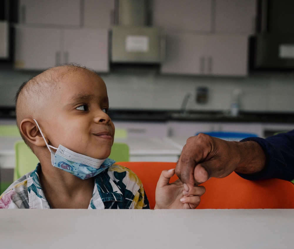 Smiling child holding hand.
