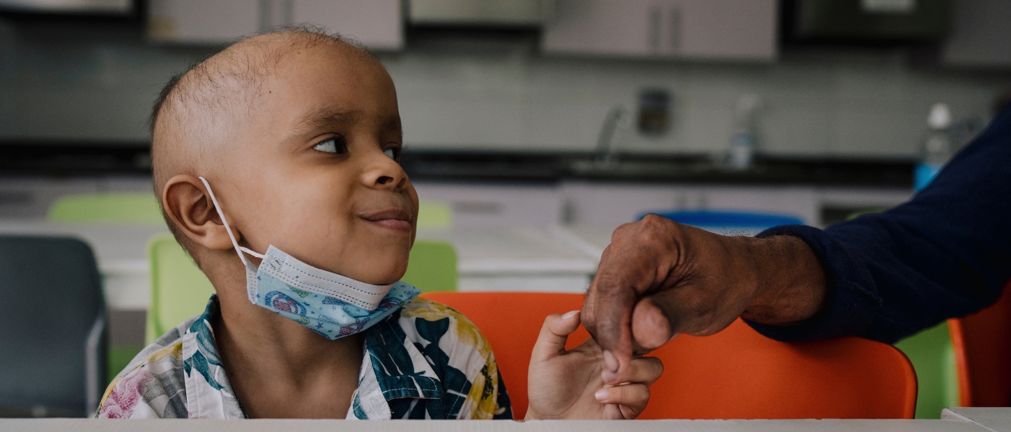 Smiling child holding hand.