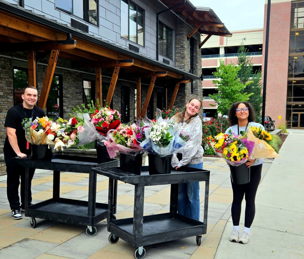 Staff in front of the House with a floral donation.