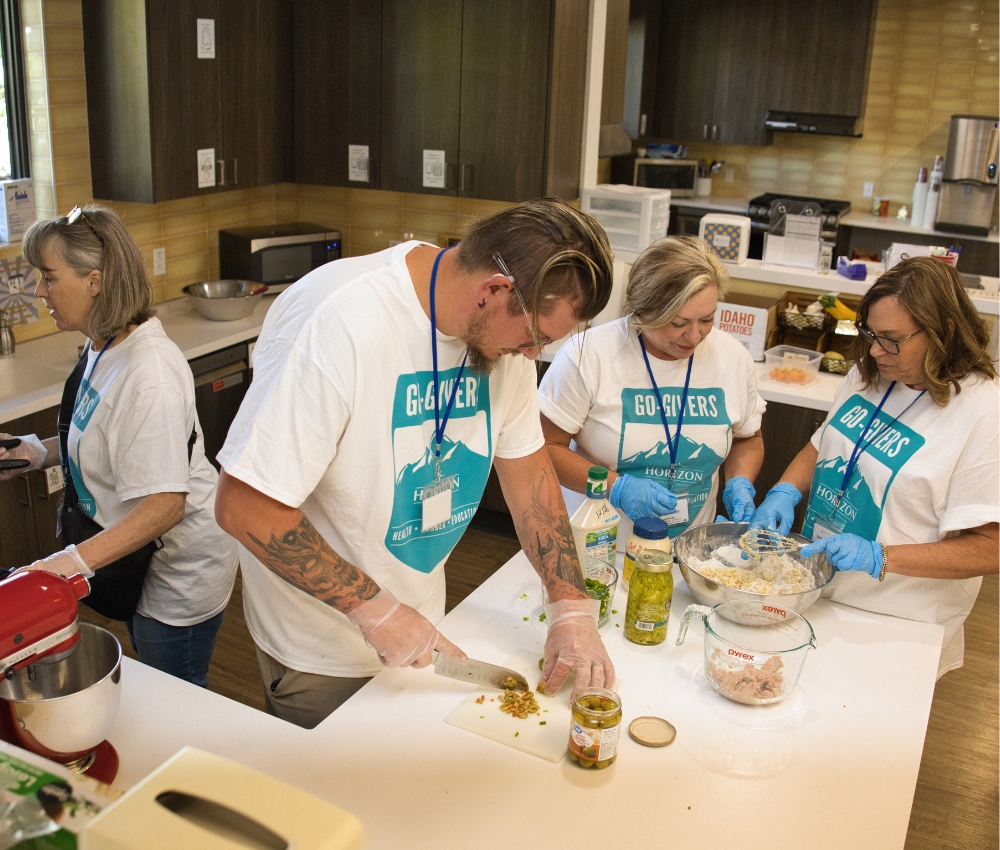 Volunteers cooking in the kitchen at the House.