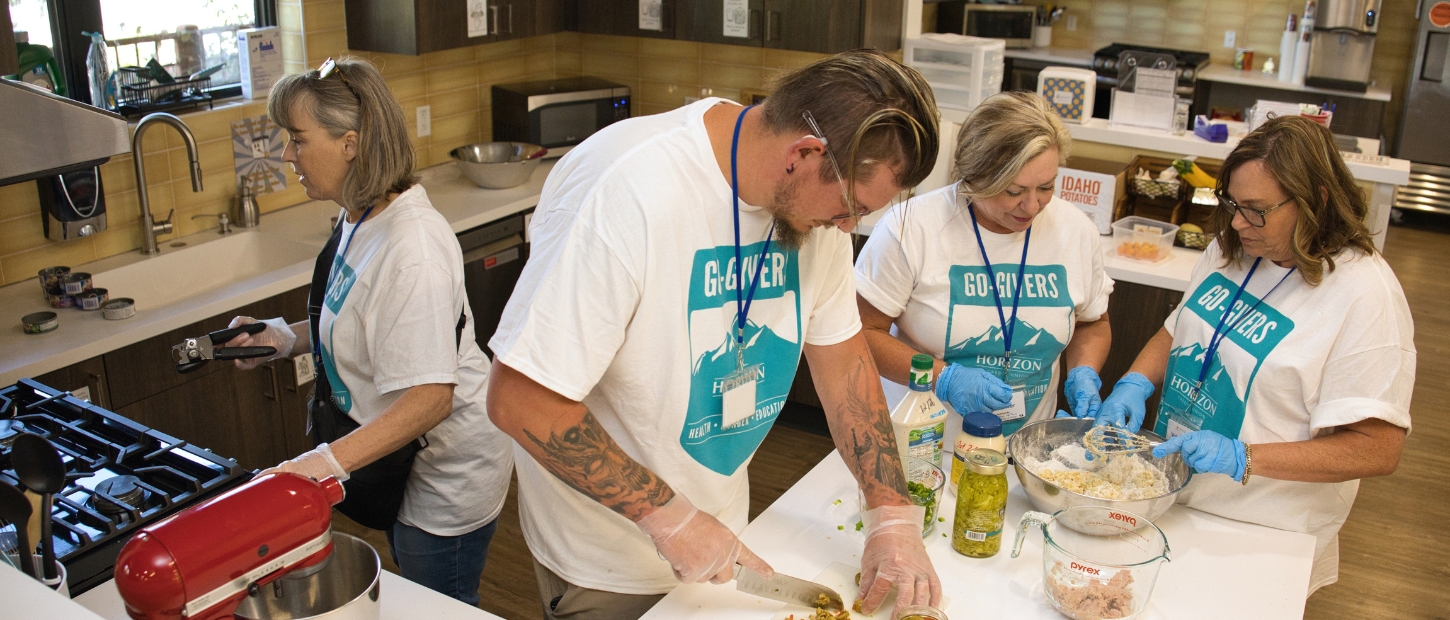 Volunteers cooking in the kitchen at the House.