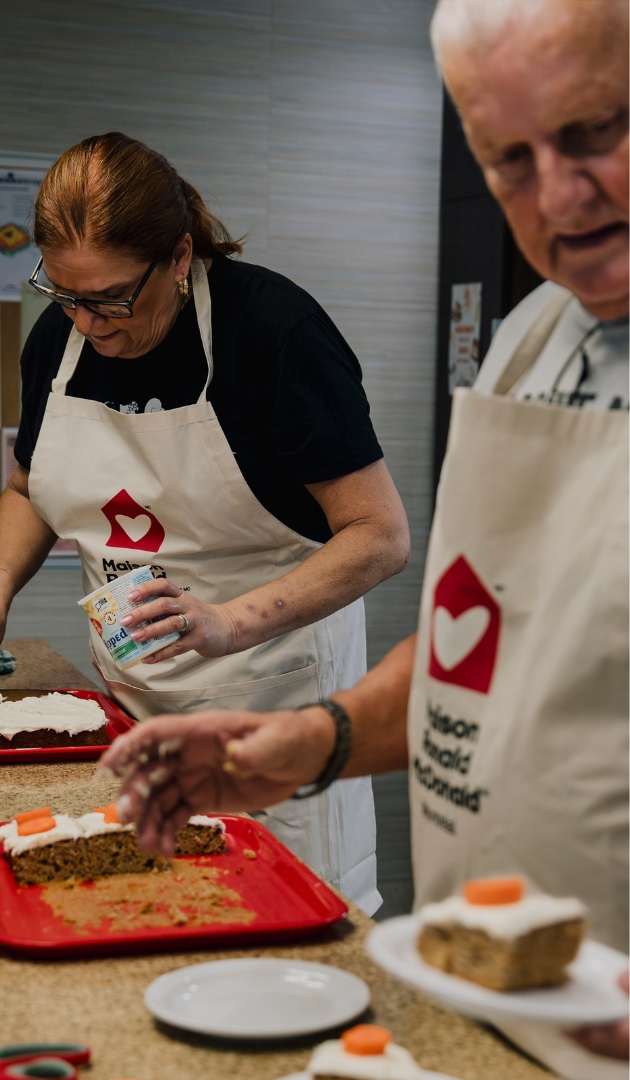 Two volunteers cooking a meal in the kitchen.