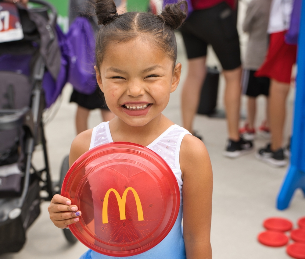 Young girl holding a McDonald's frisbee.